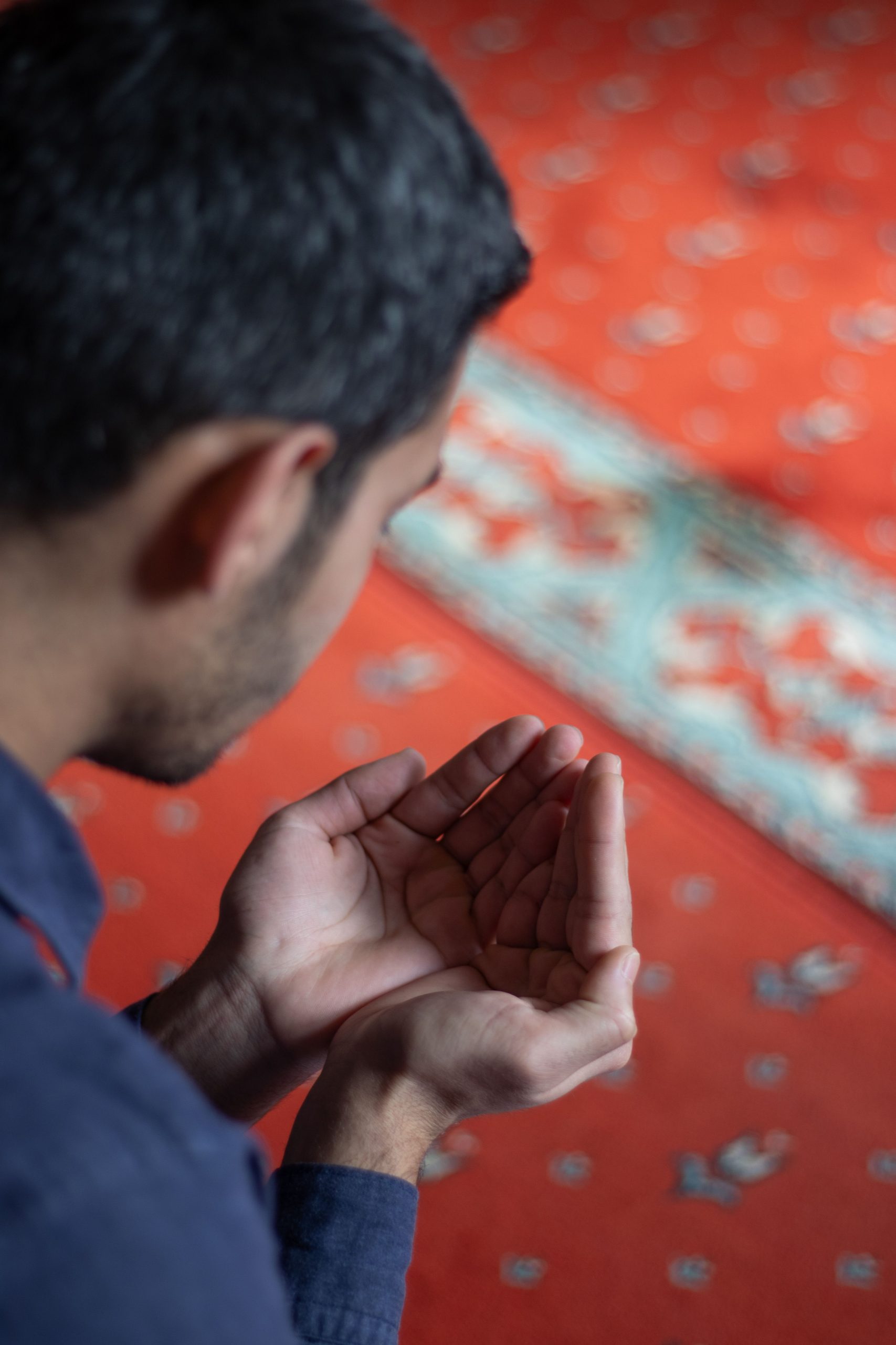 Muslim man praying on a mosque prayer carpet, representing halal-conscious prayer rug manufacturing in Indonesia